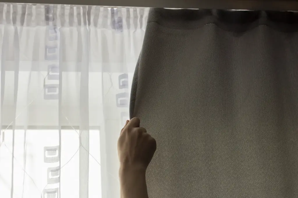 Person Rolling The Blackout Curtains, Improving Sleep with Blackout Curtains