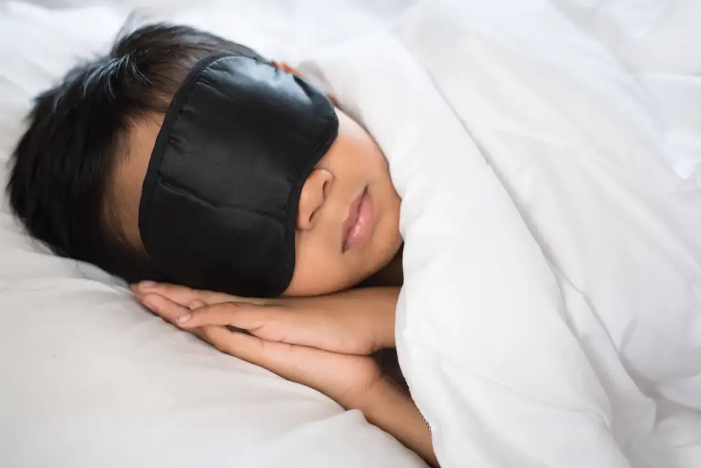 Boy Sleeping on Bed with Sleeping Mask 