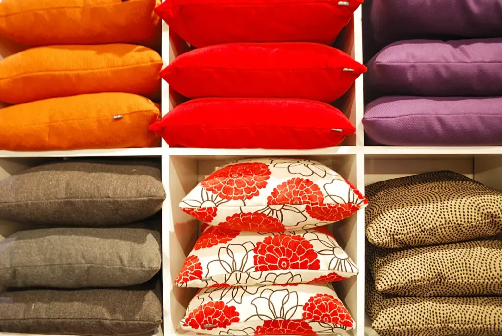 Colorful Pillows Stacked On A Shelf, Feather Pillow vs. Down Pillow