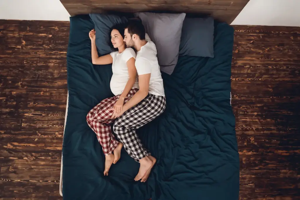 Young Couple Laying In Bed, What Is The Standard Bed Height?