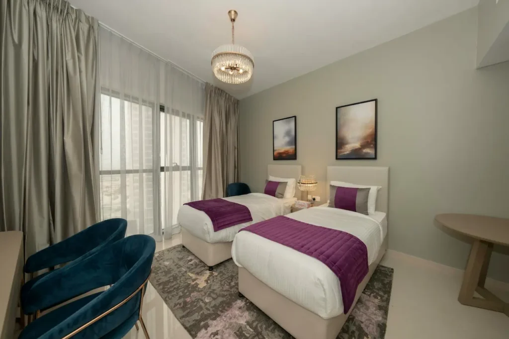 A Bedroom with Two Beds and a Desk 