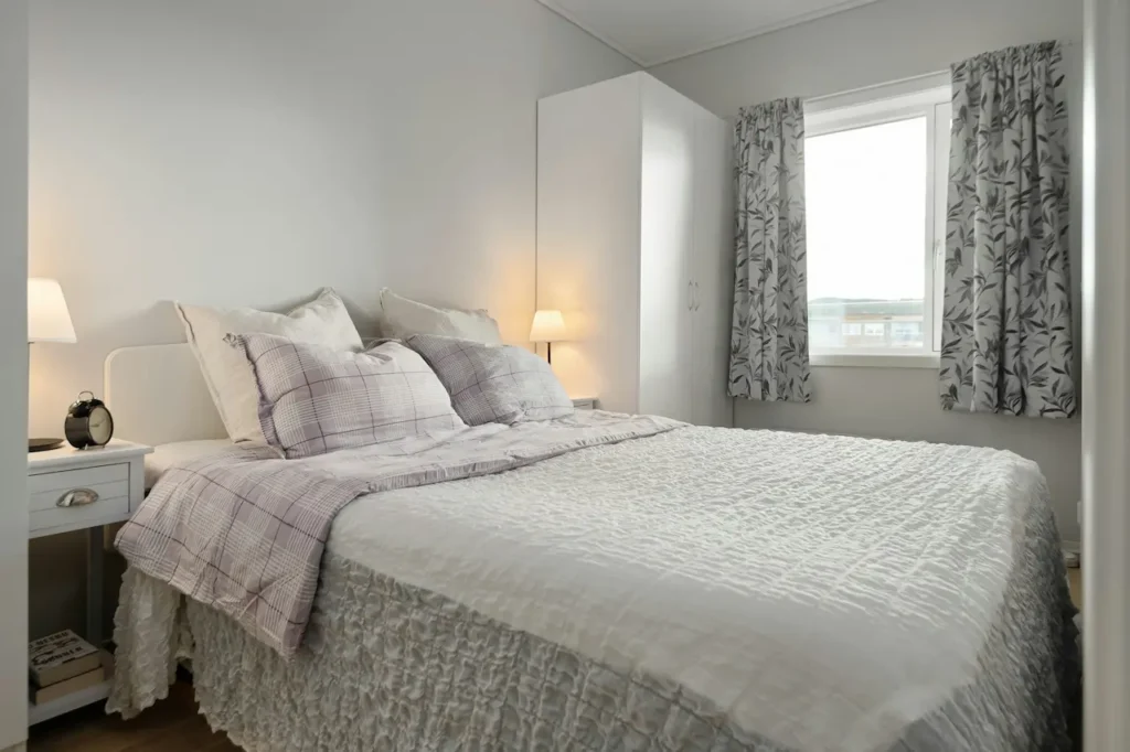 A Bedroom with White Linen Bed Sheets Near the Window