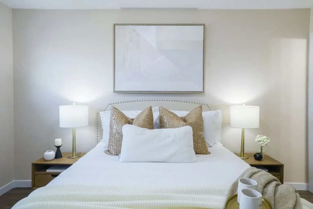A Fancy White Bedroom with Two Brown Pillows 