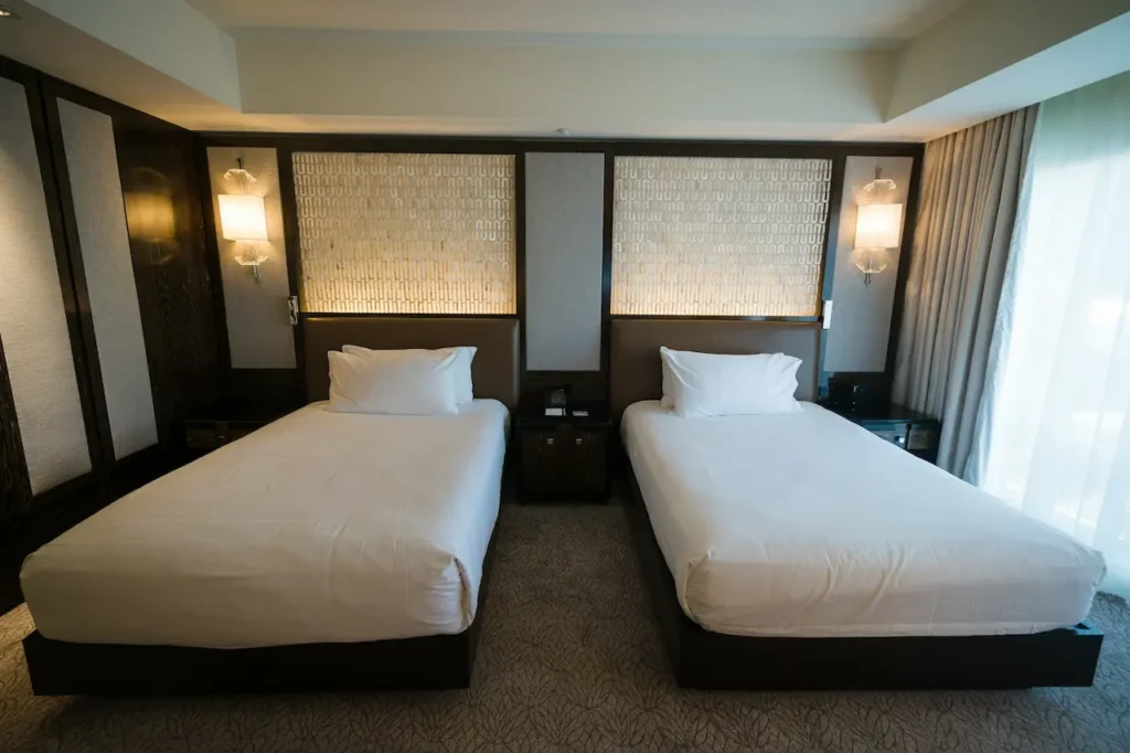 A Hotel Room with Two White Beds 