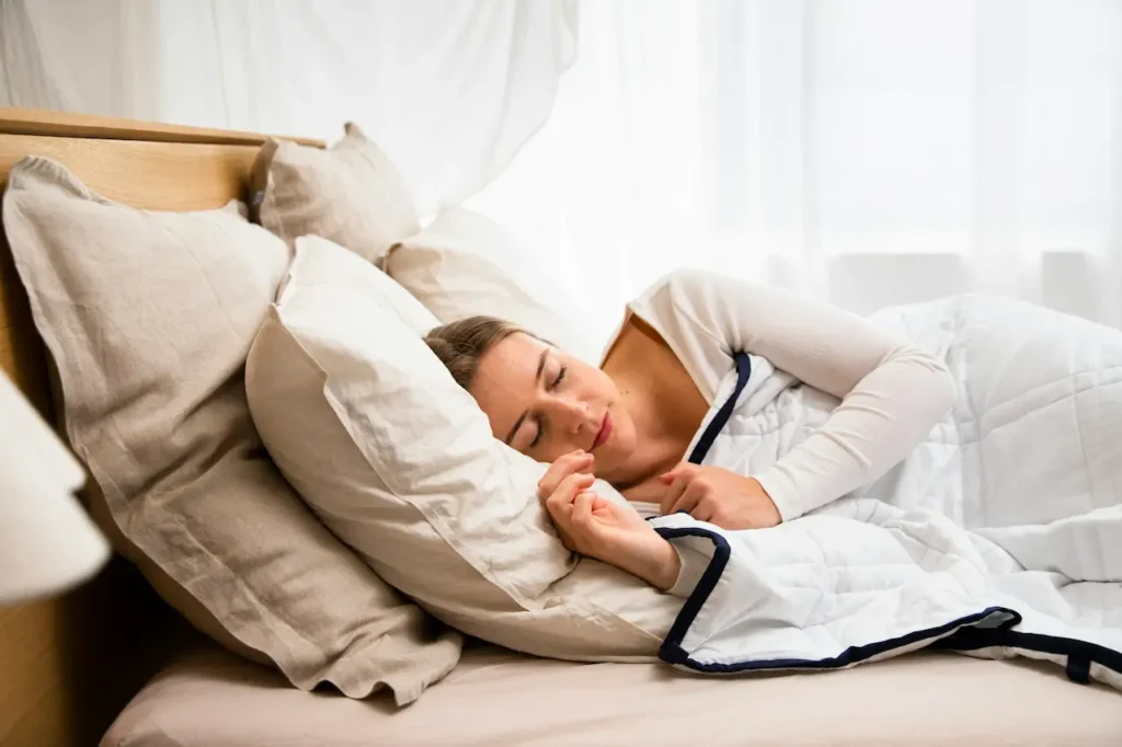 A Woman Sleeping in a Bed Covered with a White Blanket 
