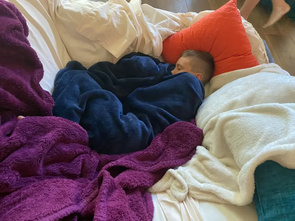 A Young Boy Sleeping Covered in a Blue Blanket