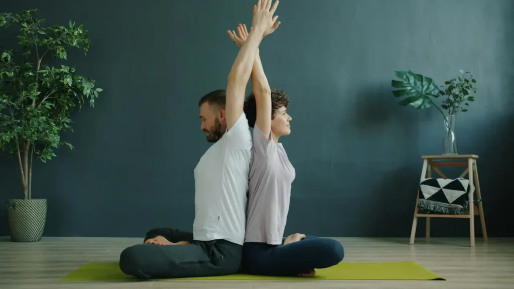 Couple Meditating Back to Back on a Yoga Mat